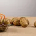 Aardappelen in een metalen mandje en los op een jute ondergrond
