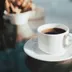 Een wit kopje zwarte koffie op een schoteltje