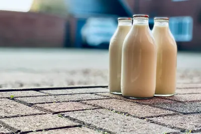 Drie glazen melkflessen op een stoep