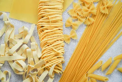 Verschillende soorten droge pasta: tagliatelle, spaghetti, penne en vlinderpasta