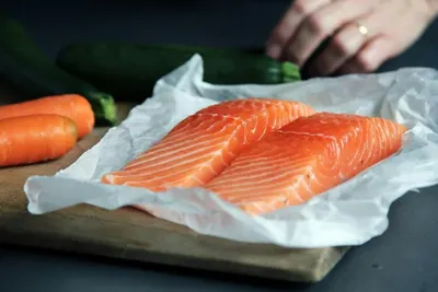 Twee verse zalmfilets op papier op een snijplank