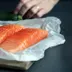 Twee verse zalmfilets op papier op een snijplank