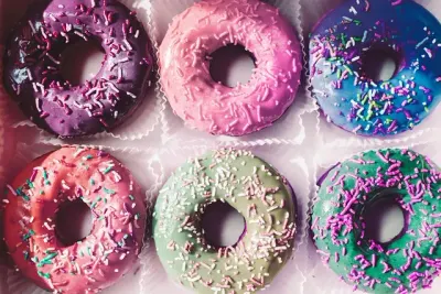 Zes geglazuurde donuts met gekleurde spikkels
