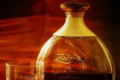 Een fles rum en een glas rum in warm licht