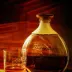 Een fles rum en een glas rum in warm licht