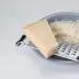 Een stuk Parmezaanse kaas met een rasp en geraspte kaas op een bord