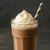 Een glas chocolademelk met slagroom en een rietje