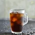 Een glas ijskoffie met ijsblokjes en koffiebonen