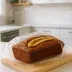 Bananenbrood verpakt in huishoudfolie op een houten plank