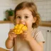 Een peuter eet van een in blokjes gesneden mango