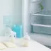 Flesjes en zakjes afgekolfde moedermelk met een borstkolf voor een open koelkast